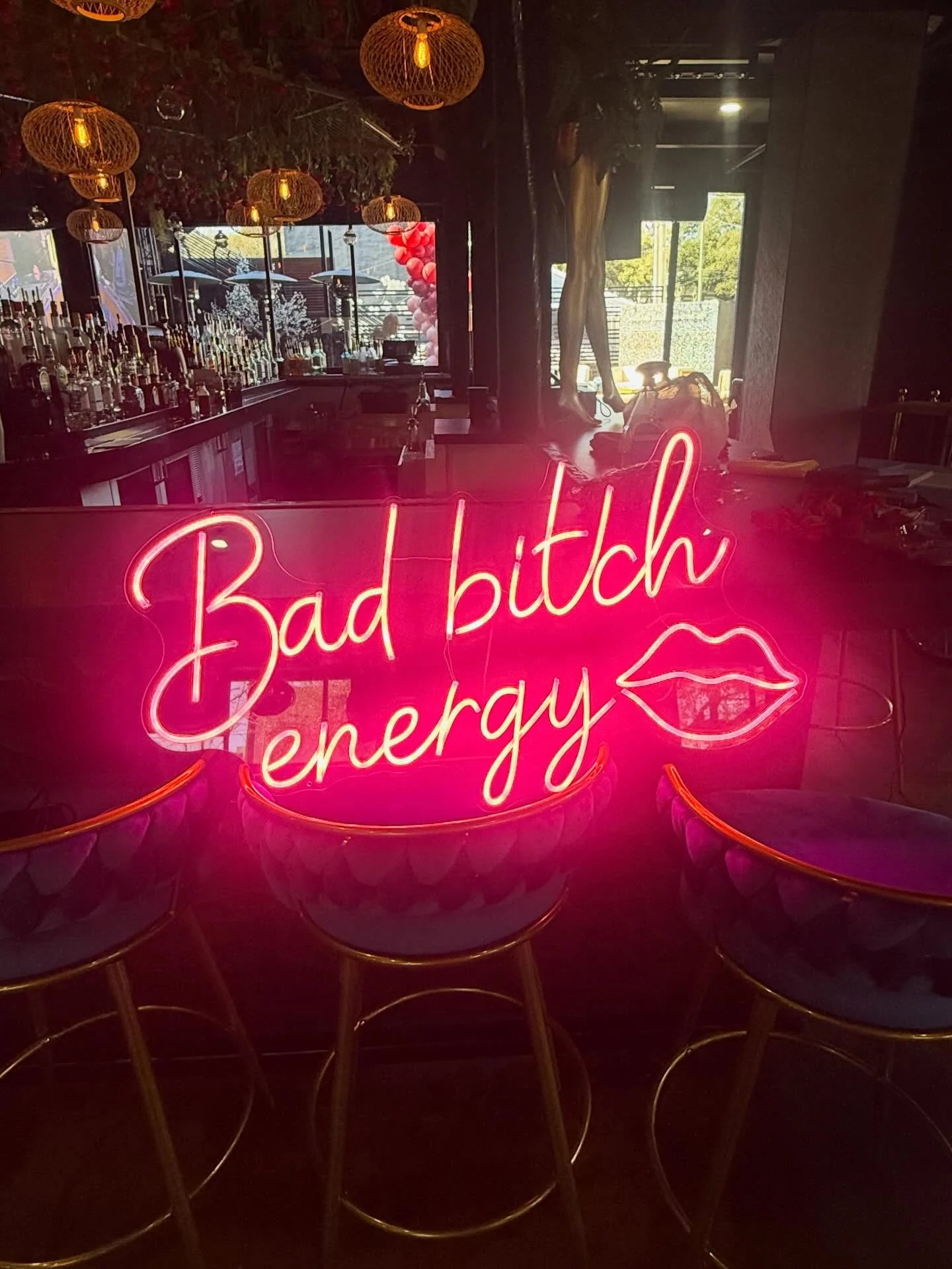 Main bar glowing under neon signage at Styx + Stone