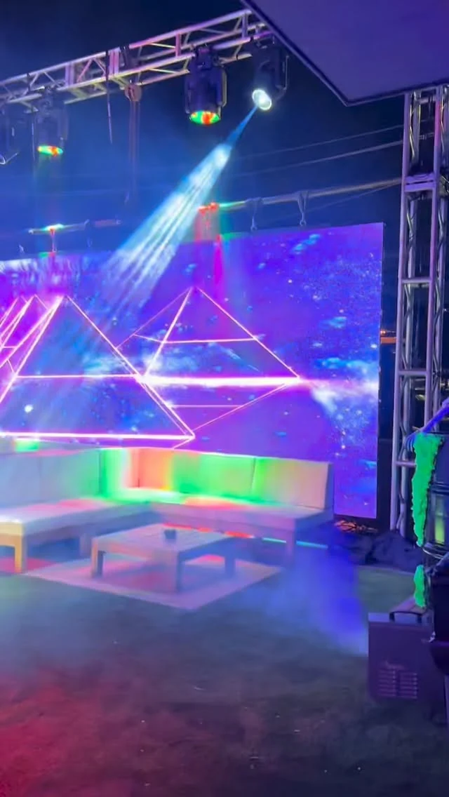 Rooftop lounge seating in front of a glowing LED wall at Styx + Stone