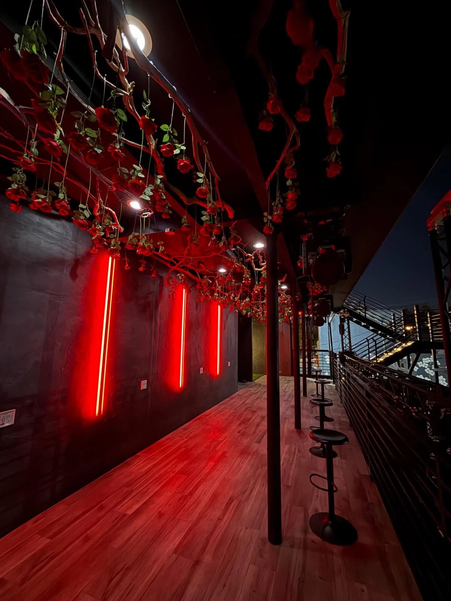 Rose-draped covered walkway on the second-floor patio at Styx + Stone