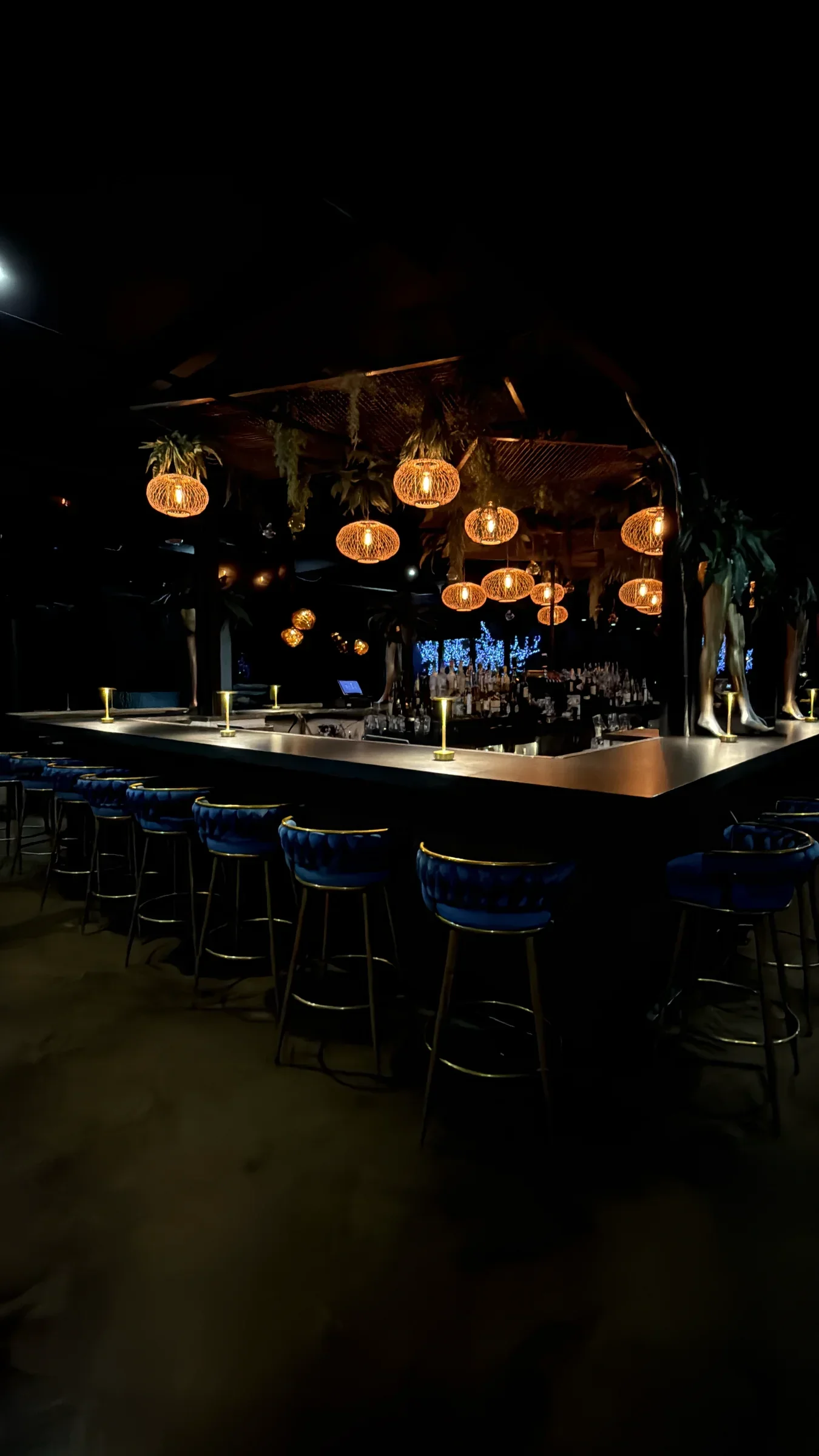 The classic ground-floor bar at Styx + Stone beneath warm sculptural lanterns