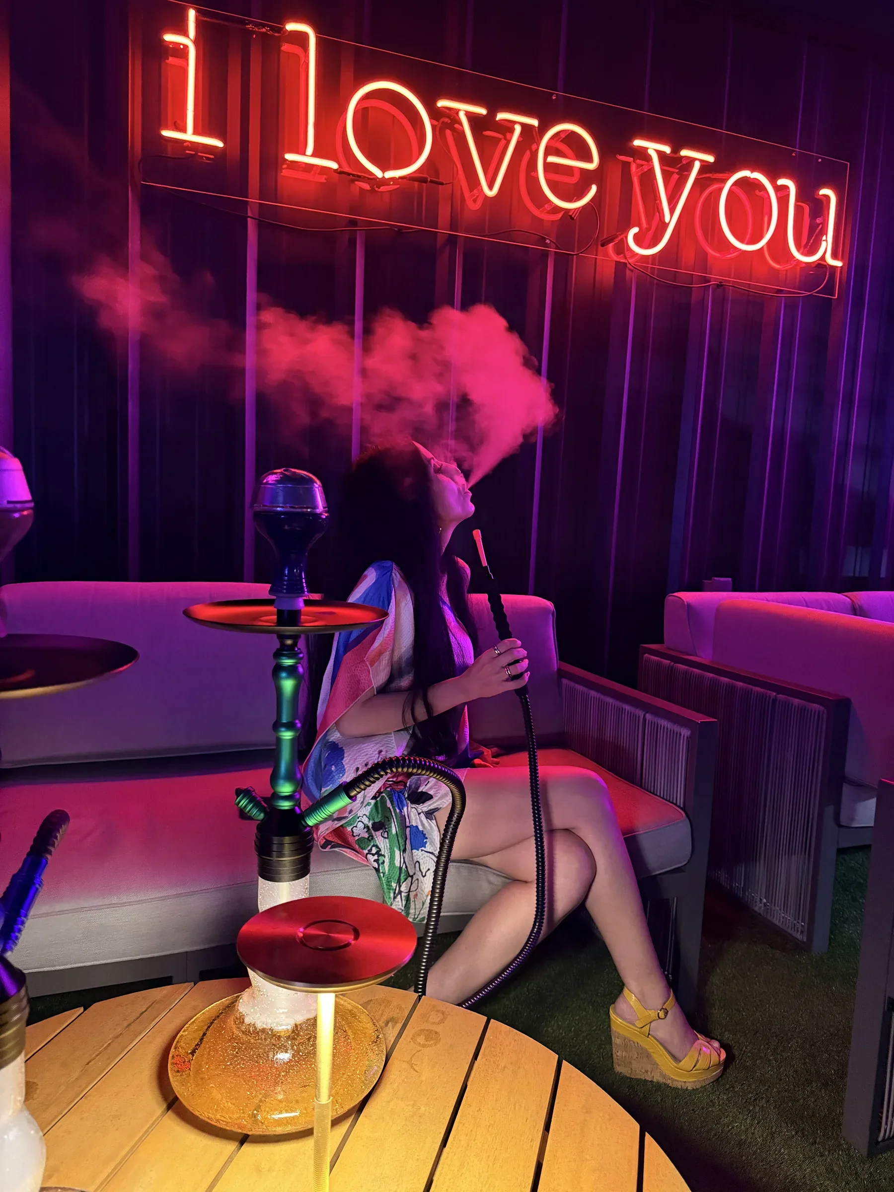 Hookah lounge beneath the "i love you" neon on the Styx + Stone rooftop