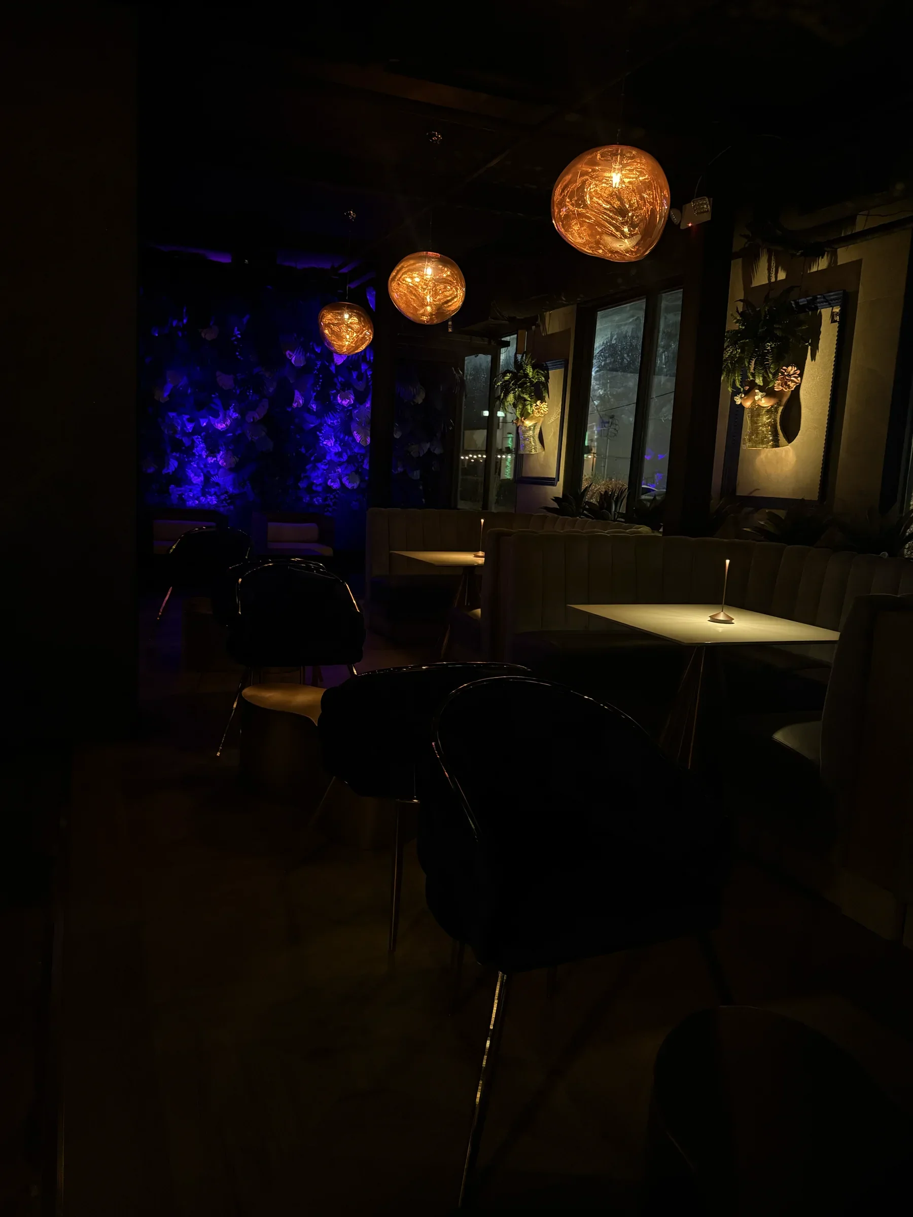 Copper lamps over the blue floral wall in the ground-floor bar at Styx + Stone