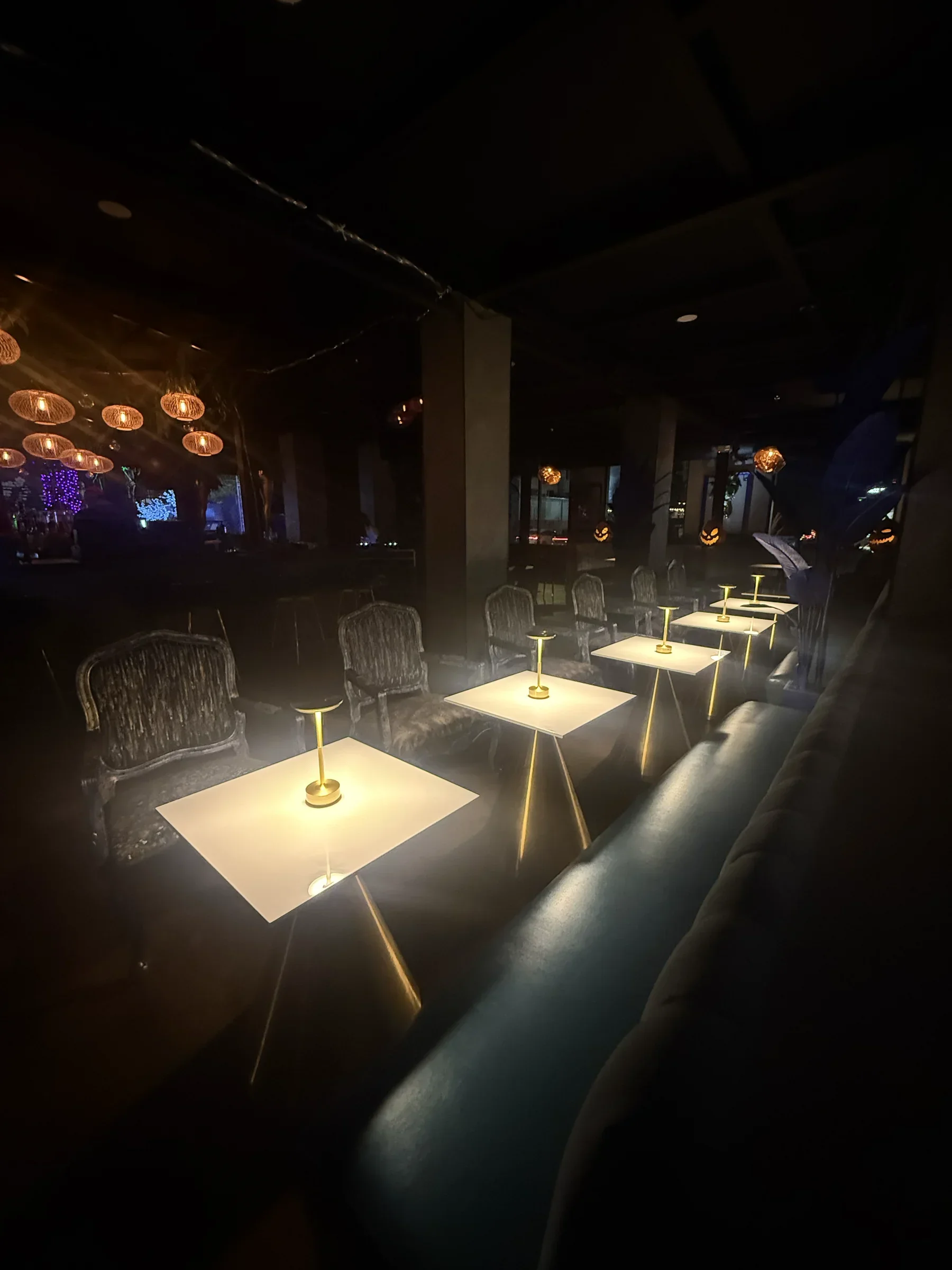 Glowing tables along the banquettes in the ground-floor bar at Styx + Stone