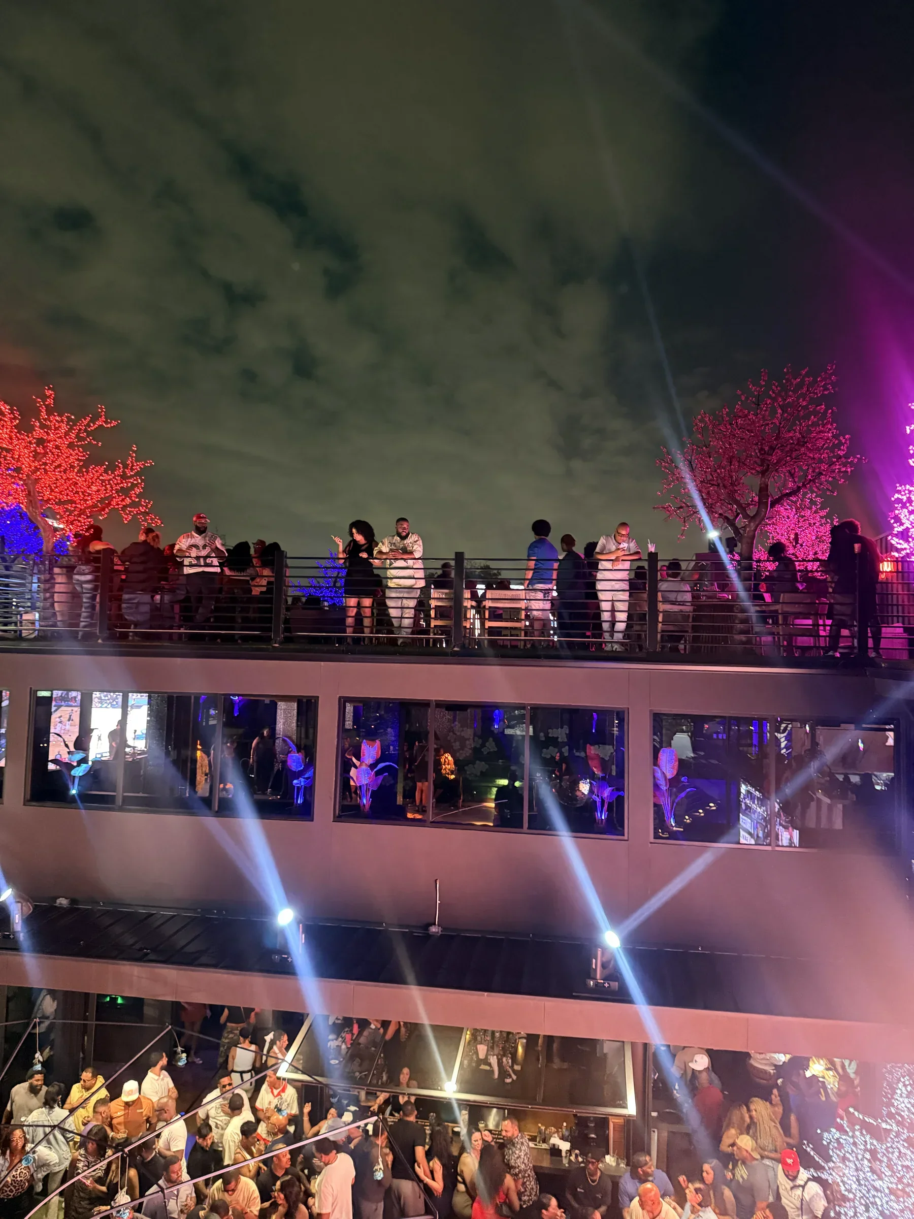 The rooftop balcony crowd above a packed floor with searchlights at Styx + Stone