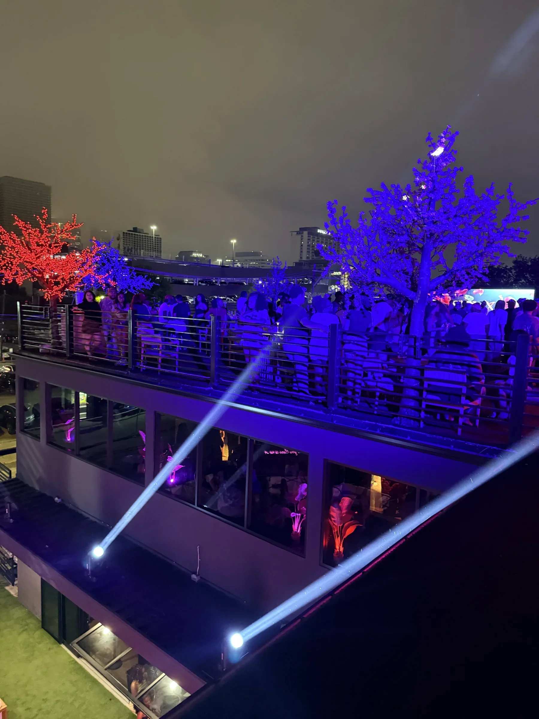 LED blossom trees in red and blue over the rooftop crowd at Styx + Stone