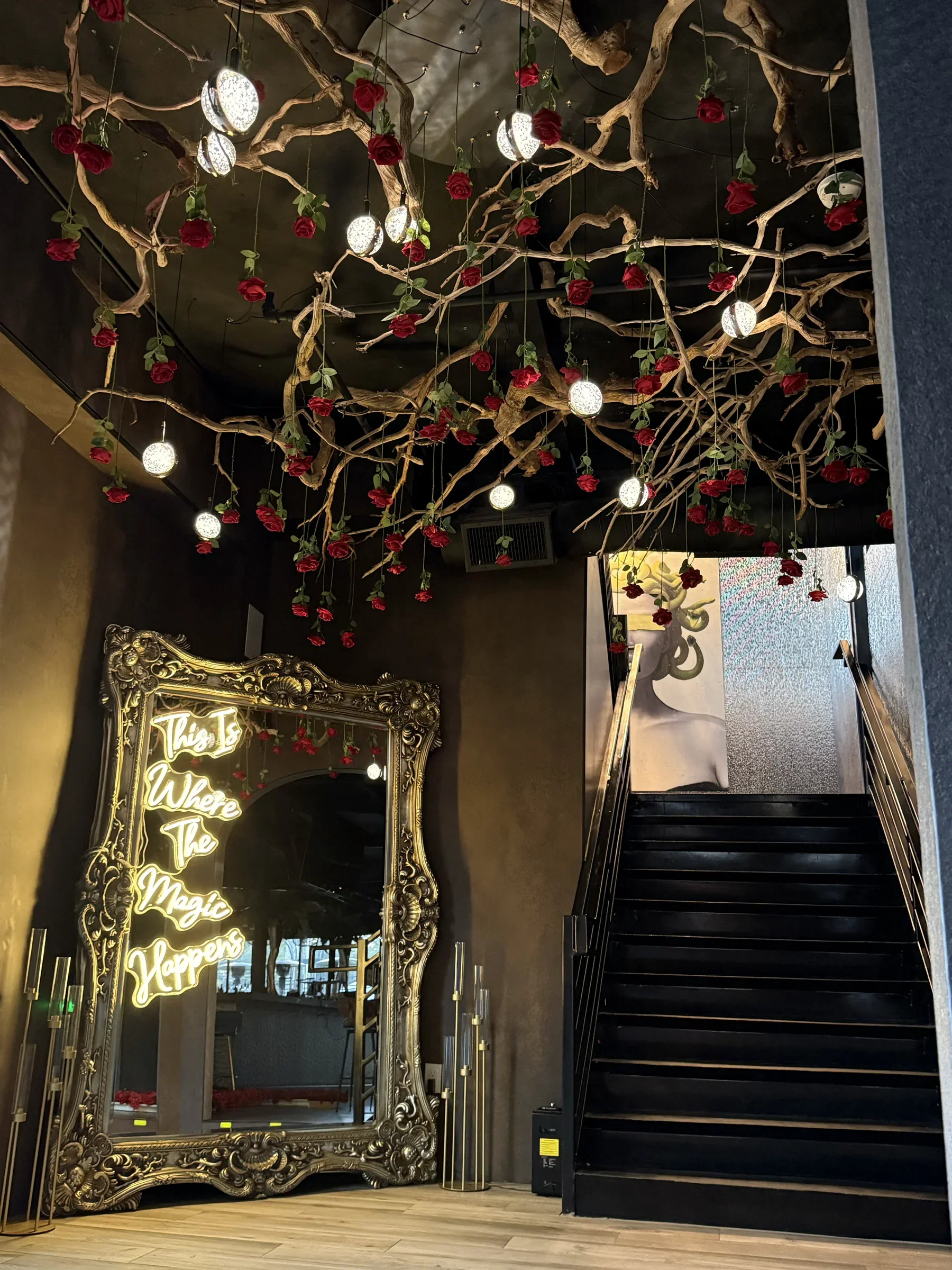 Rose vines over an ornate mirror beside the ground-floor staircase at Styx + Stone