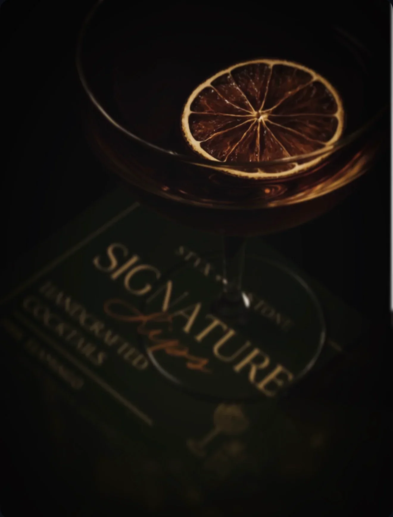 Signature cocktail with a dried citrus garnish at Styx + Stone